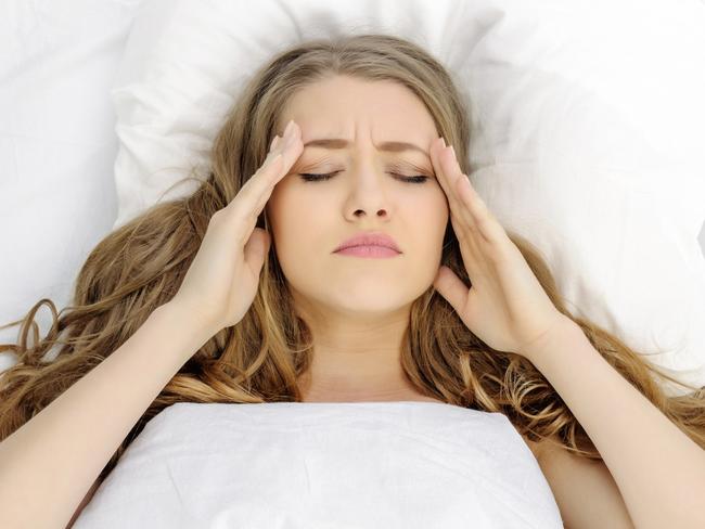 woman having insomnia and terrible headache.