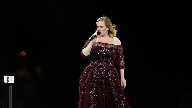 Adele’s all superstar poise on stage — but minutes before the show starts, she’s crouched in a little box being wheeled through the crowd. Picture: Morne de Klerk/Getty