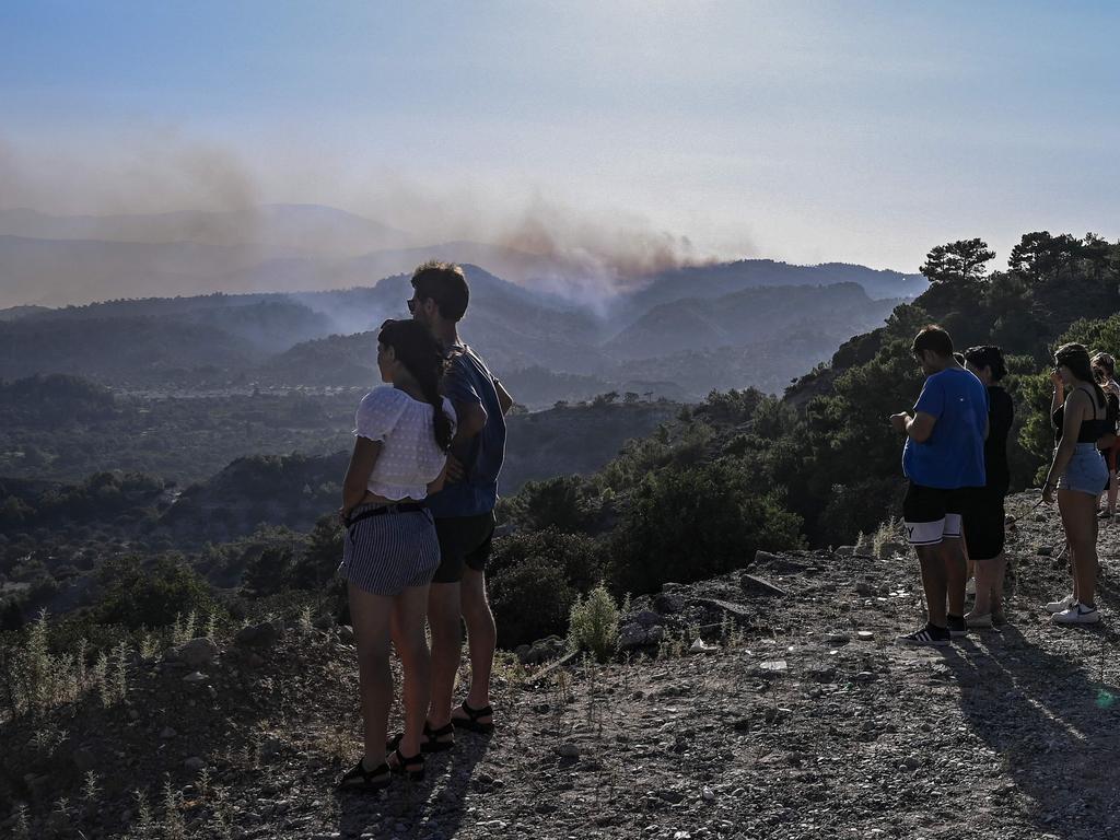 Residents stand at the top of a hill watching the fire approaching their villages on the Greek island of Rhodes. Picture: AFP