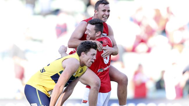 Cameron Craig and Jake Wohling celebrate on the siren of their preliminary final comeback as Eagle Jack Hayes slumps in disappointment. Picture Sarah Reed