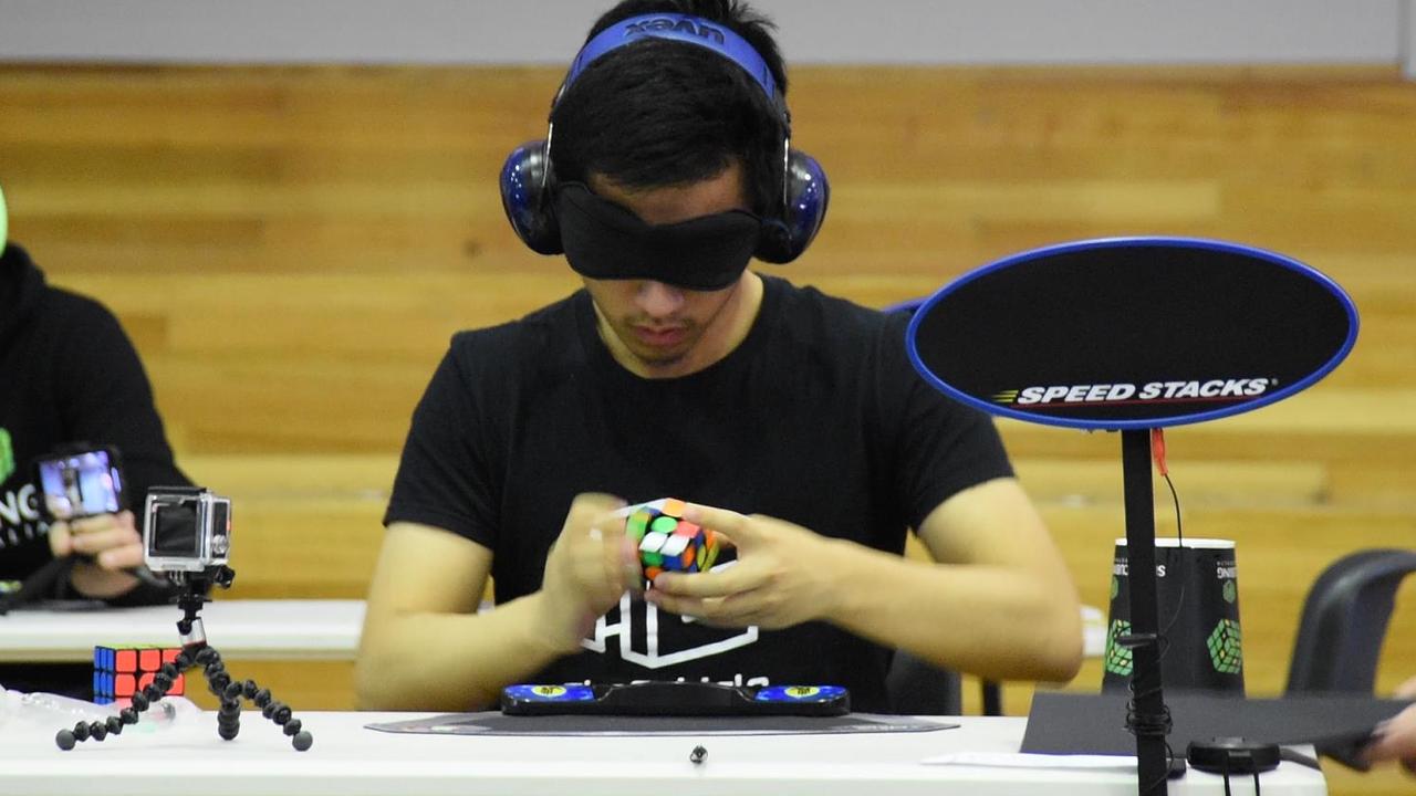 Jack Cai in action at a competition. Note the headphones to help him concentrate and that he is solving the cube while wearing a blindfold. Picture: supplied