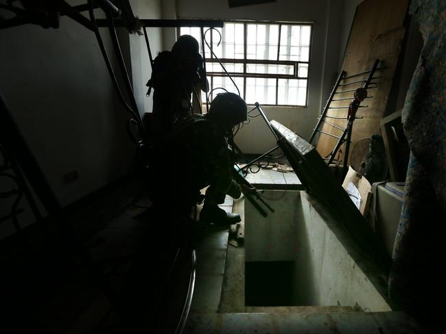 Soldiers from the 1st Field Artillery Battalion at a fire support base, outside of Marawi, inspect a cellar of an abandoned house where ISIS militants used to hide. Picture: Gary Ramage