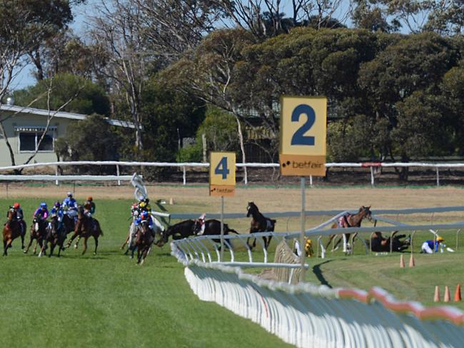 Horses and jockeys were thrown into, and under, the rail after the accident. Picture: SAM WUNDKE