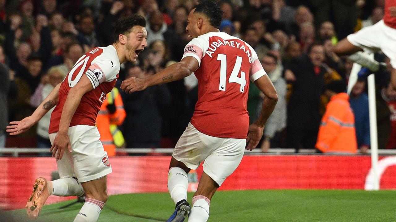 Pierre-Emerick Aubameyang (2nd L) celebrates with Mesut Ozil (L). (Photo by Glyn KIRK / IKIMAGES / AFP)