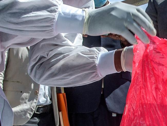 A pharmaceutical expert (L) opens a pack of expired Covid-19 Astra Zeneca vaccines to show to Malawiâs Health Minister Khumbize Kandodo Chiponda (R) before they are destroyed in a furnace at a pharmaceutical incinerator at Kamuzu Central Hospital in Lilongwe on May 19, 2021. - Malawi has destroyed nearly 17,000 doses of the AstraZeneca vaccine that had expired in mid-April, with the health minister blaming "propaganda" for many Malawians' reluctance to receive the jab. (Photo by Amos GUMULIRA / AFP)