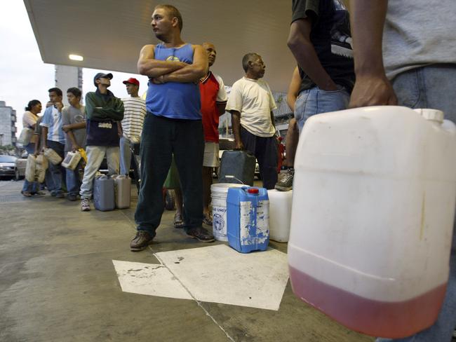 Locals wait in long lines to purchase fuel.