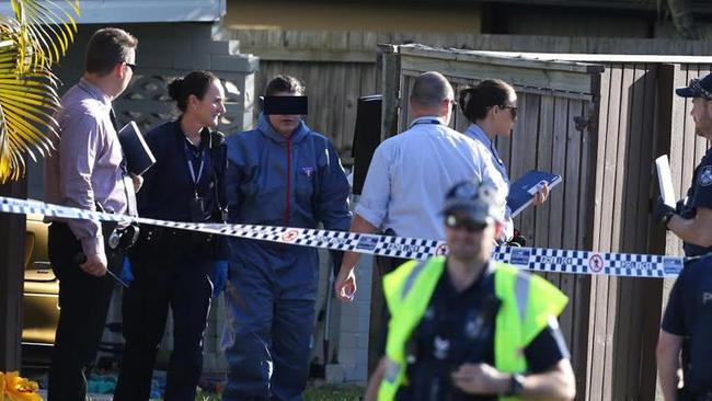 A woman is led from the scene of yesterday’s shooting death for questioning. Picture: Regi Varghese