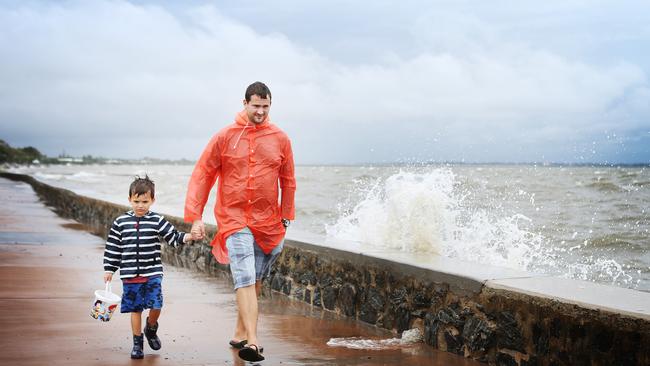 Jono Watson with son, Oliver, 5, enjoying the wet weather at Sandgate. 