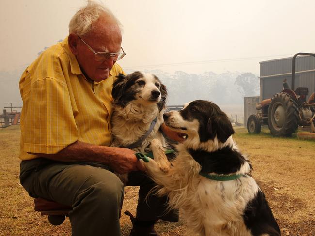 Owen Whalan with his border collies just before he was again evacuated from his home today. Picture: AAP