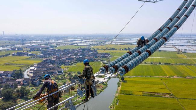 Employees working on a high-voltage direct-current transmission line in Wuxi, in China's eastern Jiangsu province. Picture: AFP