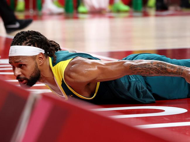 SAITAMA, JAPAN - AUGUST 05: (EDITORÃ¢â¬â¢S NOTE: Alternative crop of image #1332431086) Patty Mills #5 of Team Australia slides on the court after being fouled while driving to the basket against Team United States during the first half of a Men's Basketball quarterfinals game on day thirteen of the Tokyo 2020 Olympic Games at Saitama Super Arena on August 05, 2021 in Saitama, Japan. (Photo by Kevin C. Cox/Getty Images)