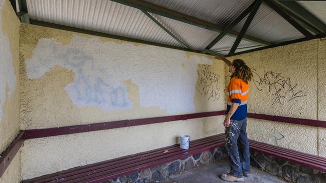 Steven O'Brien painting over the damaged gazebo walls. Picture: Valeriu Campan