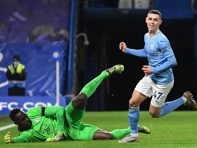 LONDON, ENGLAND - JANUARY 03: Phil Foden of Manchester City celebrates after scoring their sides second goal as Edouard Mendy of Chelsea looks dejected during the Premier League match between Chelsea and Manchester City at Stamford Bridge on January 03, 2021 in London, England. The match will be played without fans, behind closed doors as a Covid-19 precaution. (Photo by Andy Rain -
