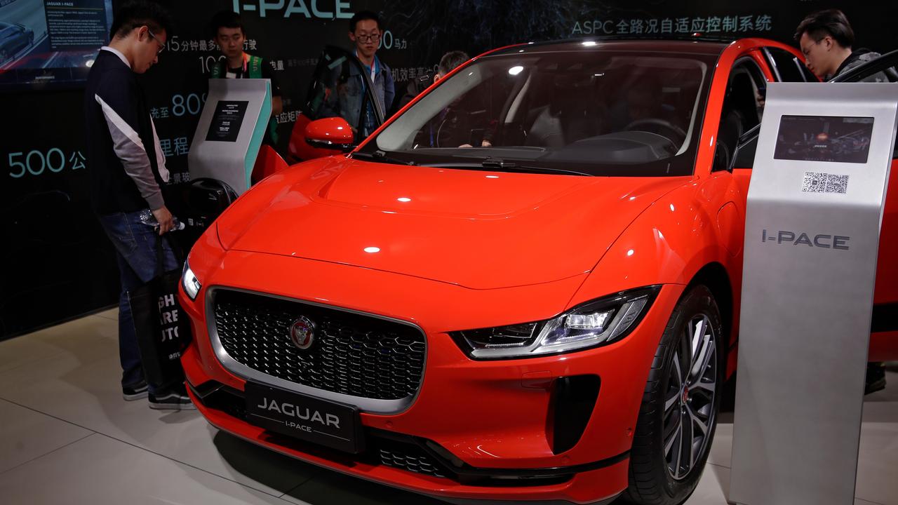 Journalists and visitors look at the Jaguar electric-powered I-Pace model. Picture: AP