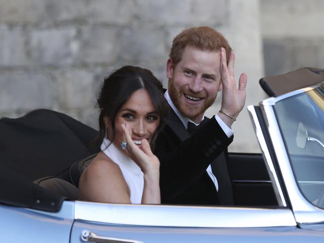 FILE - In this Saturday, May 19, 2018 file photo the newly married Duke and Duchess of Sussex, Meghan Markle and Prince Harry, leave Windsor Castle in a convertible car after their wedding in Windsor, England, to attend an evening reception at Frogmore House, hosted by the Prince of Wales. Prince Harry and Meghan Markle are to no longer use their HRH titles and will repay Â£2.4 million of taxpayer's money spent on renovating their Berkshire home, Buckingham Palace announced Saturday, Jan. 18. 2020. (Steve Parsons/pool photo via AP, File)