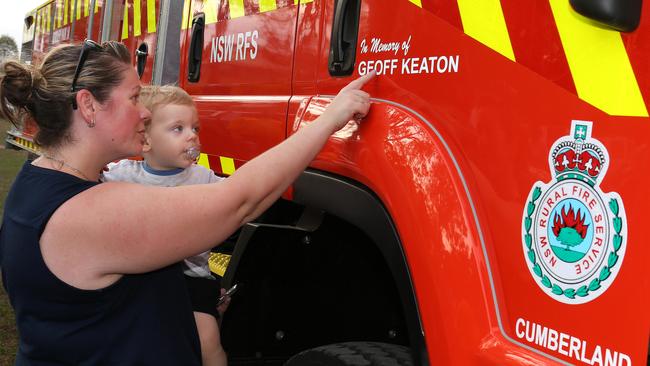 Geoff’s wife Jessica and son Harvey chanted “we love you daddy” as they adhere the transfer of Geoff Keaton on the new fire truck at Horsley Park. Picture: Robert Pozo