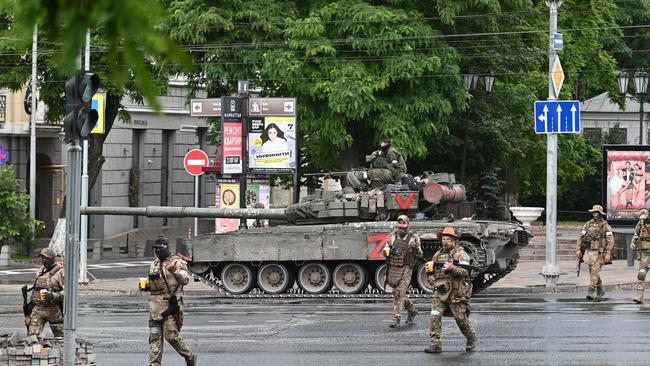 Fighters of Wagner private mercenary group cross a street as they get deployed near the headquarters of the Southern Military District in the city of Rostov-on-Don, Russia. Picture: Reuters