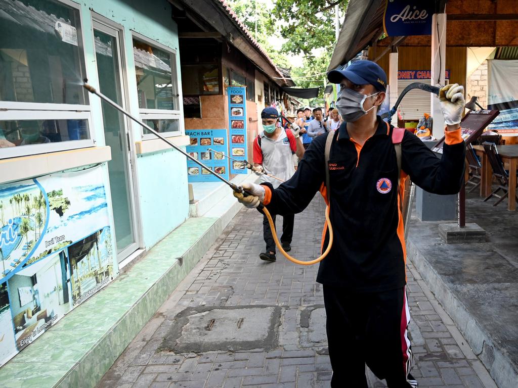A health worker sprays disinfectant in the Bali area of Sanur in March. Picture: Sonny Tumbelaka/AFP