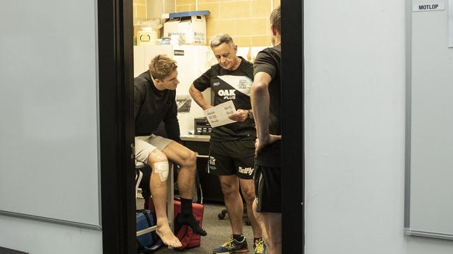 Hamish Hartlett catches up with club doctor Mark Fisher and physio Mike Heynen at Alberton Oval following surgery on his anterior cruciate ligament. Picture SARAH REED