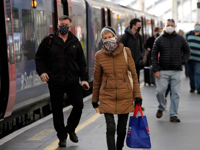 Travellers disembark from a train at Waterloo Station in London. brits have been told to stay home over the holiday season. Picture: AFP