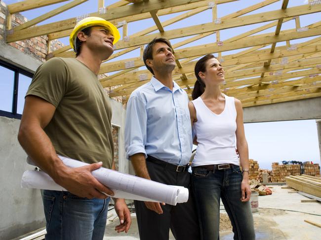 Couple with contractor inside structure during the building of their home.