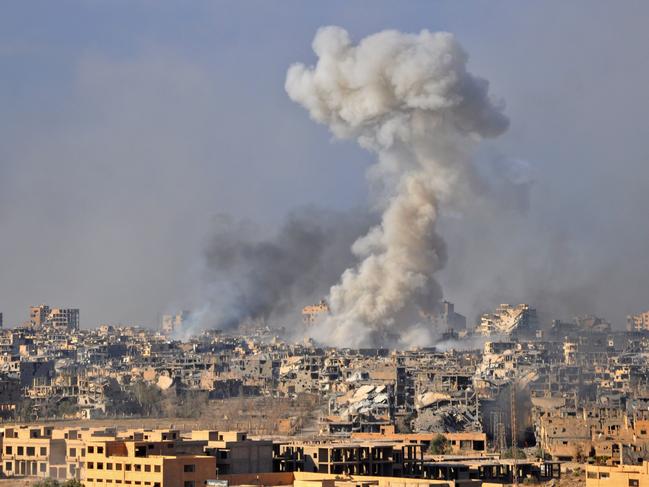 TOPSHOT - Smoke rises from buildings following an air strike by Syrian government forces in the eastern city of Deir Ezzor, on October 31, 2017, during an operation against Islamic State (IS) group jihadists. The Assad regime has been able to recapture more than half of Syria's territory with the support of Russian air strikes. It is now focusing on the oil-rich eastern province of Deir Ezzor, where the SDF alliance is also involved.  / AFP PHOTO / STRINGER