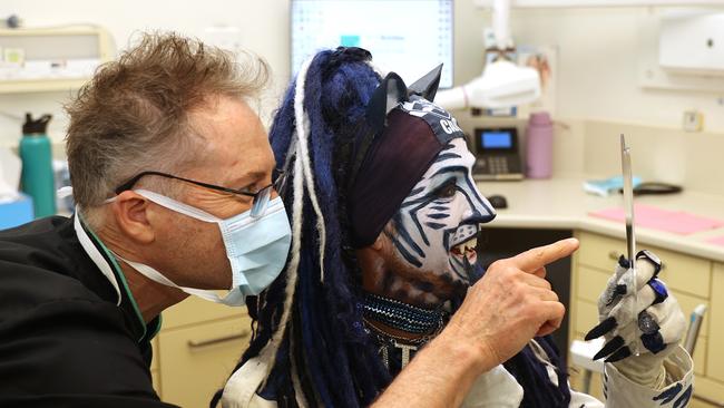 "Catman" Troy West from the Geelong footy cheer squad checks out his new fangs with Totally Smiles Dr Simon McPherson. Picture: Alison Wynd