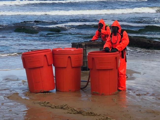 Drums of a mystery substance, believed to be hydrochloric acid, washed up on a Newcastle beach on Sunday. Picture: Fire and Rescue NSW.