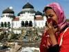 28 Dec 2004: A woman near a mosque surrounded by debris from the tsunami which hit Banda Aceh, triggered by a 9.0 earthquake ...