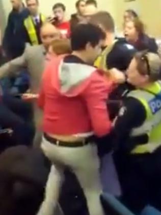 Police help the former MP to safety.