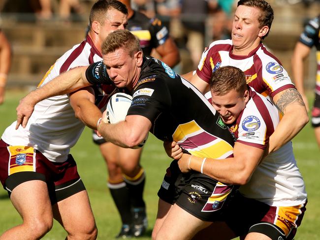 Hills Bulls player Tim Robinson attempts to barge through the defence.