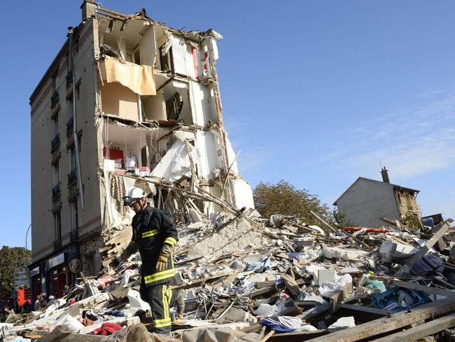A firefighter searches through the rubble of a four-storey residential building that collapsed following a blast in Paris. AFP PHOTO / BERTRAND GUAY