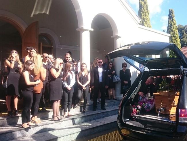 Mourners blow bubbles as Tina Kontozis is taken away from her funeral service.