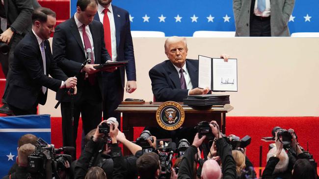 President Donald Trump holds up an executive order after signing it during an indoor inauguration parade at Capital One Arena in Washington, DC. Picture: Getty Images/AFP