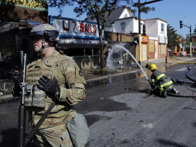 Members of the National Guard secure the area as firefighters continue to douse flames Saturday morning following protests. Picture: AP Photo/Julio Cortez