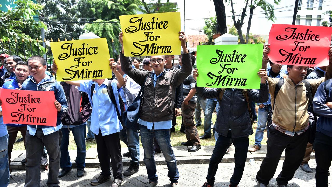 Relatives of victim Wayan Mirna Salihin hold signs outside the Central Jakarta court. Picture: Bay Ismoyo/AFP