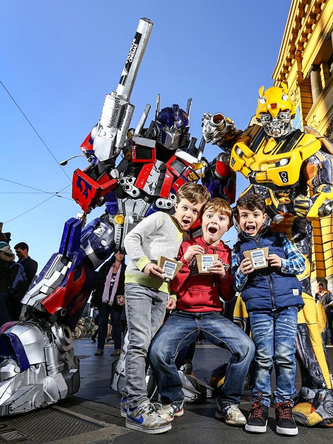 Optimus Prime and Bumblebee surprise Felix, Aaron, and Sam, on the steps of Flinders Street Station in Melbourne. Picture: Tim Carrafa