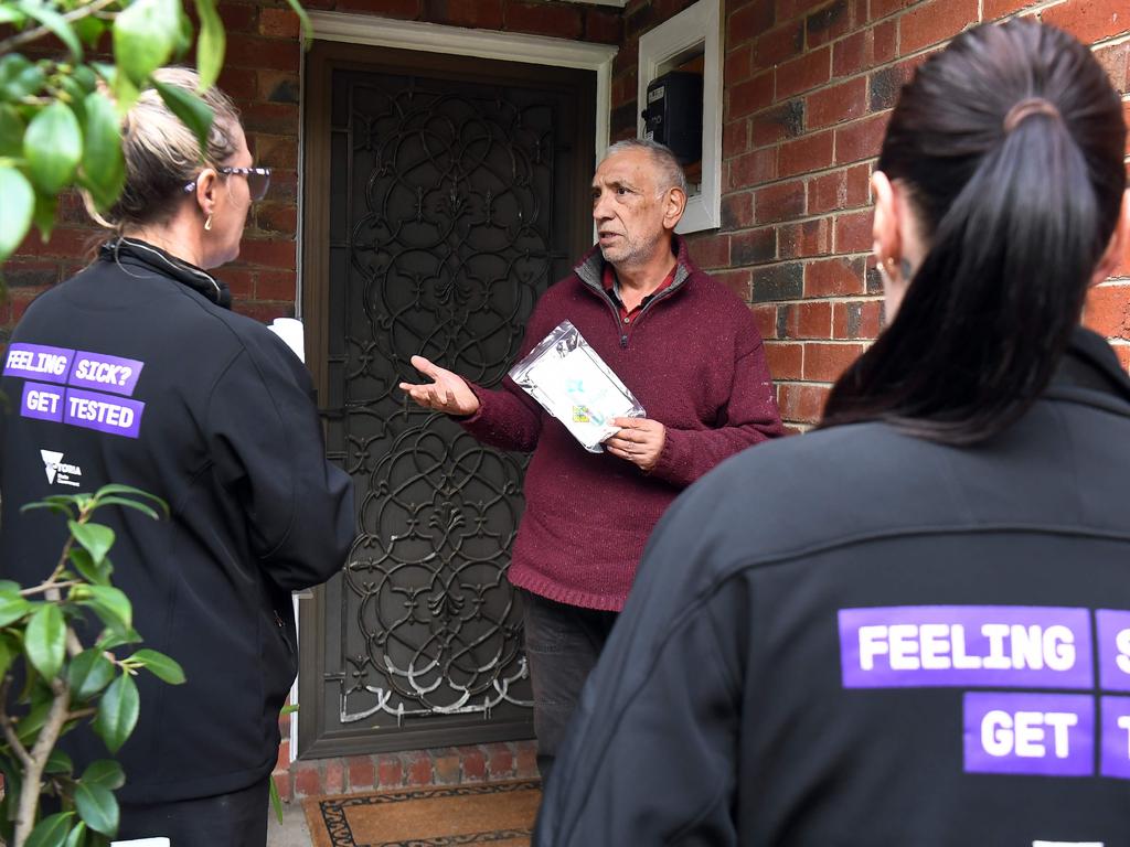 Health workers speak to a local in the locked down Melbourne suburb of Brunswick West. Picture: William West/AFP