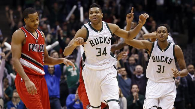 Milwaukee Bucks' Giannis Antetokounmpo and John Henson celebrate in front of Portland Trail Blazers' C.J. McCollum after Henson blocked a shot in the final seconds of the second half.