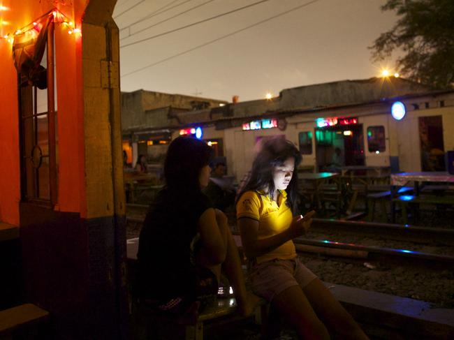 A woman checks her phone in a brothel area in Jakarta, Indonesia. Picture: Ed Wray/Getty Images