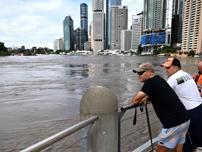 BRISBANE, AUSTRALIA - NewsWire Photos - FEBRUARY 28, 2022.People watch the swollen Brisbane River, covering the riverside walkway near Howard Smith Wharves. Queensland experiences the worst flooding in 30 years.Picture: NCA NewsWire / Dan Peled