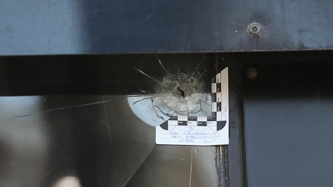 A bullet hole in the front window of City of Ink. Picture: David Crosling