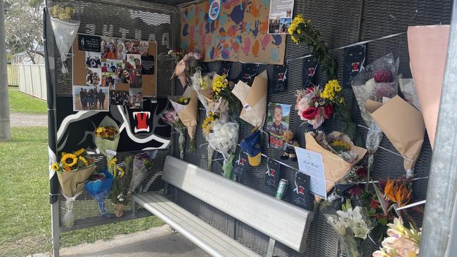 The memorial for Michael Warburton at a bus stop on Kianawah Rd where the Brisbane man was killed in a tragic hit and run crash.