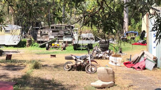 A motorbike and two caravans along with screen doors and other rubbish are strewn across the back yard. Picture: Judith Kerr