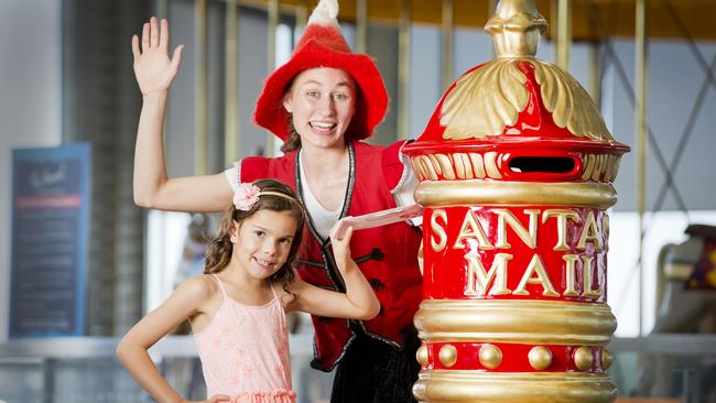 Six-year-old Mya Powe gets some help from Central Geelong magic meter elf Sugarplum Jingles to post a letter to Santa. Picture: Nathan Dyer