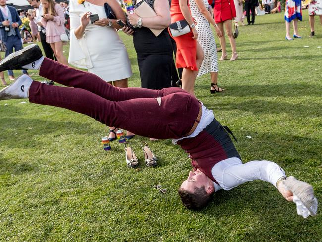 Melbourne Cup. Birdcage. Aftermath. A punter attempts to do a backflip. Picture: Jake Nowakowski