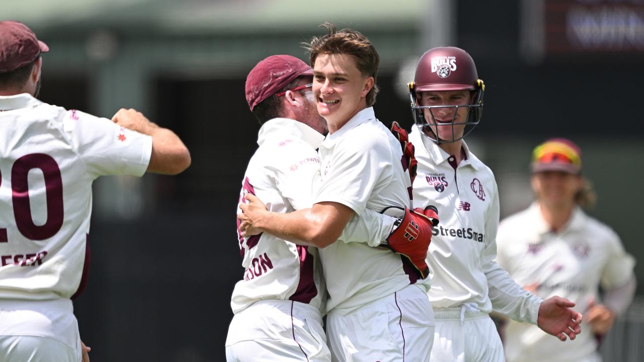 Queensland teammates celebrate with debutant bowler Tom Whitney after he claimed his fifth wicket on the second day of the Sheffield Shield clash against South Australia at Allan Border Field. Picture: Bradley Kanaris / Getty Images