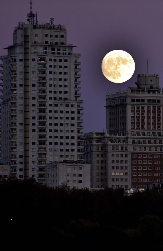 The moon rises behind the España building in Madrid, on November 13, 2016, on the eve of a “supermoon”. On November 14, 2016, the moon will orbit closer to the earth than at any time since 1948, named a ‘supermoon’, it is defined by a Full or New moon coinciding with the moon’s closest approach to the Earth. Picture: AFP PHOTO / GERARD JULIEN