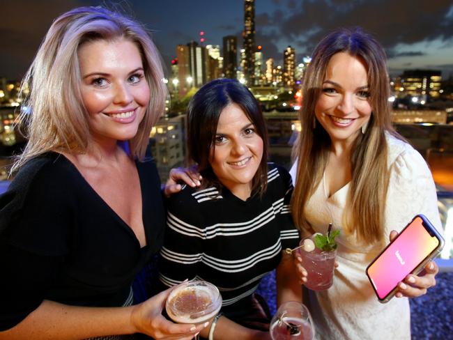 Bec Towey from Woolloongabba, Shannon Johnston from North Lakes, Jacqueline Platt from Paddington, having a drink with friends and using the BeemIT app. Picture: Steve Pohlner