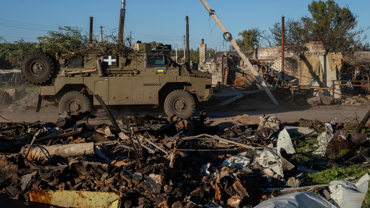 An Australian-built Bushmaster armoured vehicle is driven past destroyed buildings on October 08, 2022 in Lozove, Ukraine. Picture: Getty Images